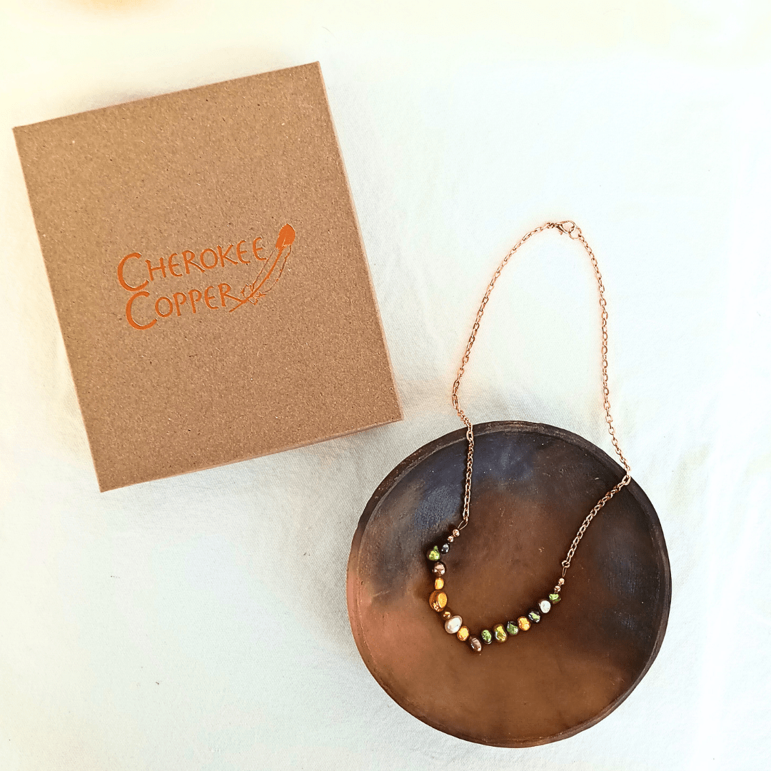 Cherokee Copper necklace with beads on a brown plate