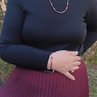 Woman wearing red jewelry and black top