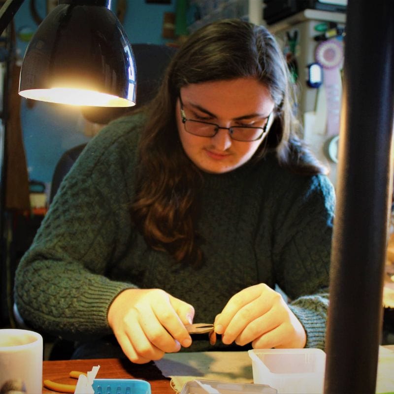 Joshua making jewelry at work table