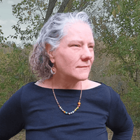 Woman wearing Lisa Tellico earrings & Three Sisters necklace