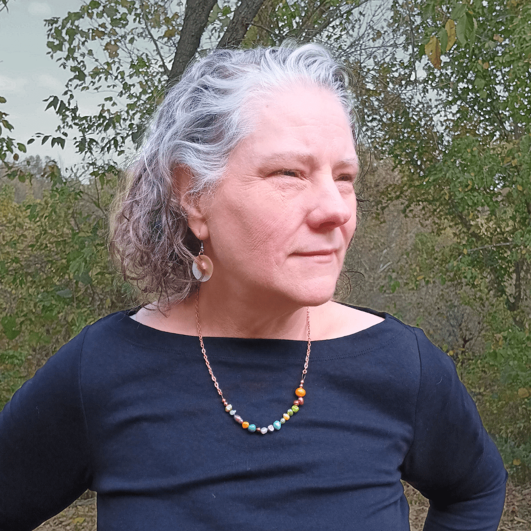 Woman wearing Lisa Tellico earrings & Three Sisters necklace