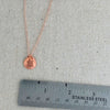 Rose gold turtle pendant necklace and ruler.