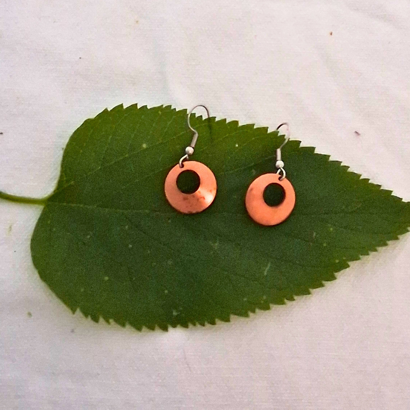 Nora earrings by Cherokee Copper on green leaf