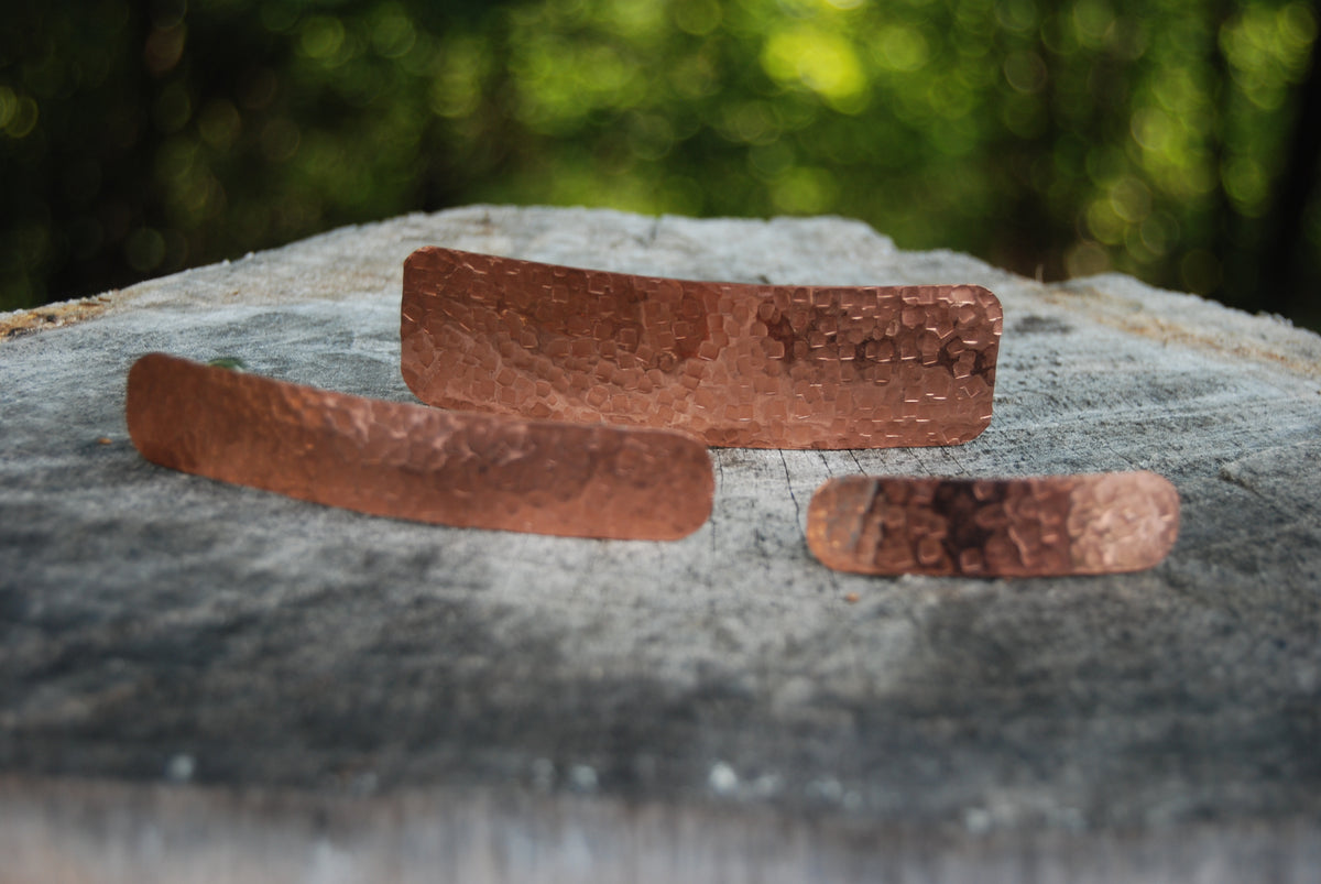 Copper jewelry pieces on wood