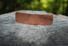 Copper hammered metal object on wood